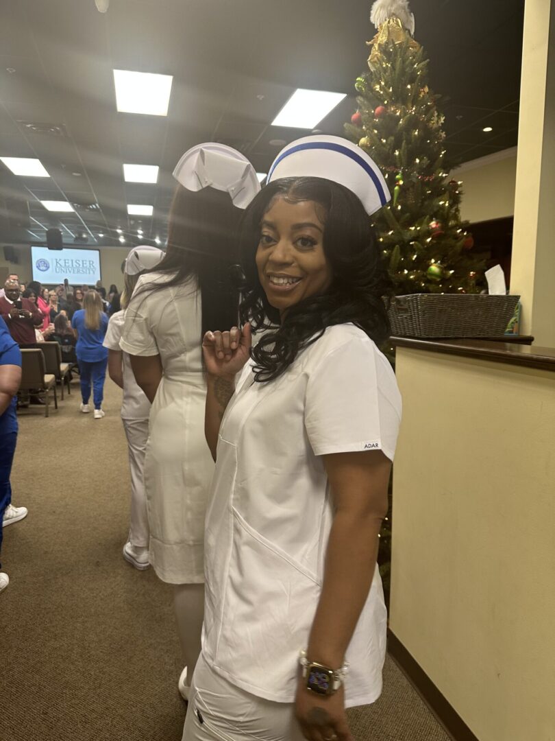Woman smiling in white nursing uniform and cap.